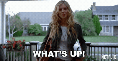 A Woman Is Standing In Front Of A House And Saying What 'S Up GIF