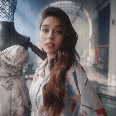 A Woman Is Standing In Front Of A Mannequin Wearing A Shirt GIF