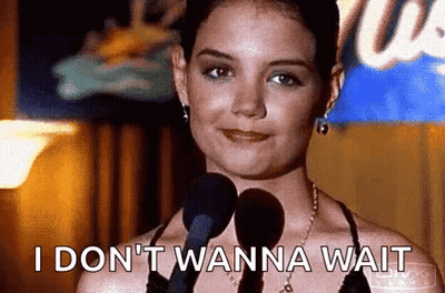 A Woman Is Standing In Front Of A Microphone And Says I Don 'T Wanna Wait . GIF