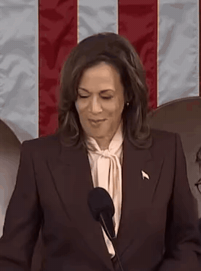 A Woman Is Standing In Front Of A Microphone And Smiling . GIF