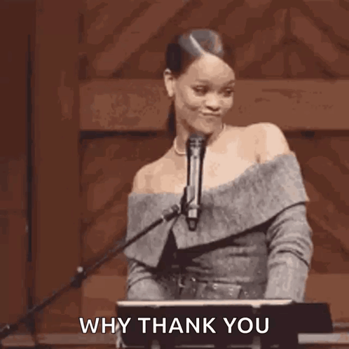 A Woman Is Standing In Front Of A Microphone Holding Her Hair In A Ponytail . GIF