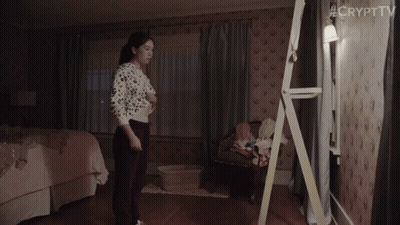 A Woman Is Standing In Front Of A Mirror In A Bedroom With #Crypttv Written On The Bottom Right Corner GIF