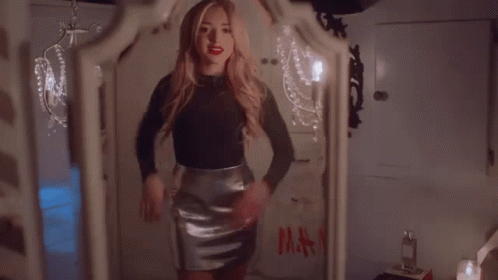 A Woman Is Standing In Front Of A Mirror With A Bag That Says H & M On It GIF