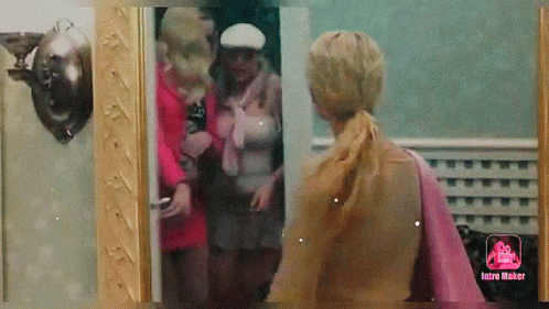 A Woman Is Standing In Front Of A Mirror With The Word Intro Maker On The Bottom GIF