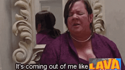 A Woman Is Standing In Front Of A Mirror With The Words It 'S Coming Out Of Me Like Lava Above Her GIF