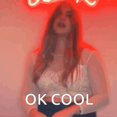 A Woman Is Standing In Front Of A Neon Sign That Says " Ok Cool " GIF