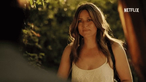 A Woman Is Standing In Front Of A Netflix Ad GIF