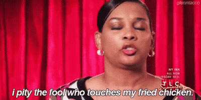 A Woman Is Standing In Front Of A Red Curtain And Says I Pity The Fool Who Touches My Fried Chicken . GIF