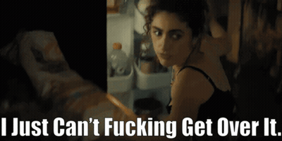 A Woman Is Standing In Front Of A Refrigerator With The Words " I Just Can 'T Fucking Get Over It " Below Her GIF