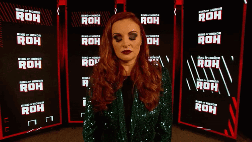 A Woman Is Standing In Front Of A Ring Of Honor Banner GIF