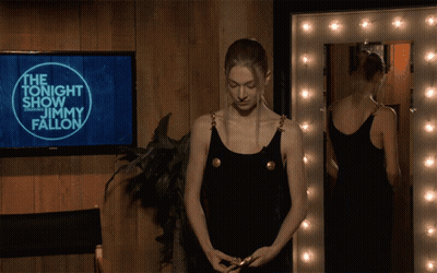 A Woman Is Standing In Front Of A Screen That Says Jimmy Fallon GIF