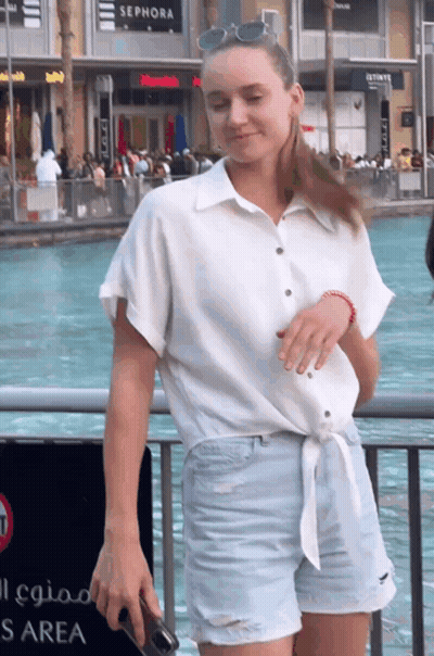 A Woman Is Standing In Front Of A Sephora Sign GIF