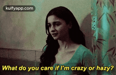 A Woman Is Standing In Front Of A Shower Curtain And Talking To Someone . GIF