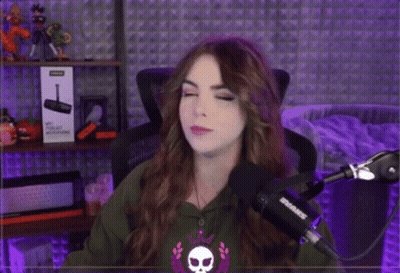 A Woman Is Standing In Front Of A Shure Microphone And Pointing GIF