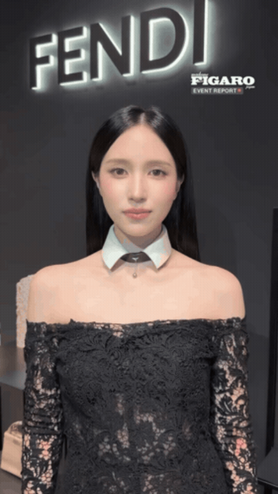 A Woman Is Standing In Front Of A Sign That Says Fendi GIF