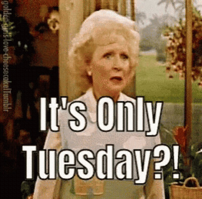 A Woman Is Standing In Front Of A Sign That Says It 'S Only Tuesday ! GIF