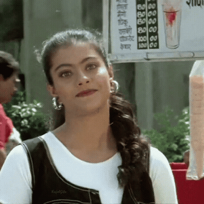 A Woman Is Standing In Front Of A Sign That Says ' Juice ' On It GIF