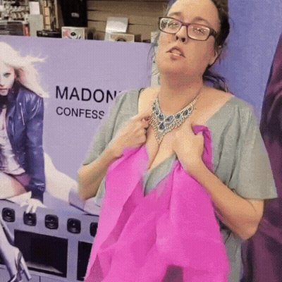 A Woman Is Standing In Front Of A Sign That Says Madon Confess GIF