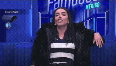 A Woman Is Standing In Front Of A Sign That Says Mexico On It . GIF