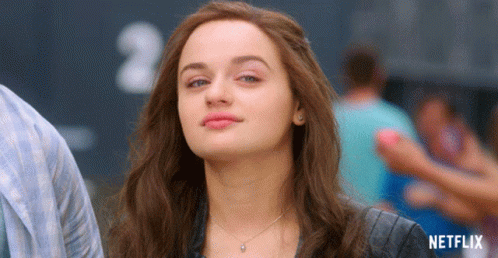 A Woman Is Standing In Front Of A Sign That Says Netflix On It GIF