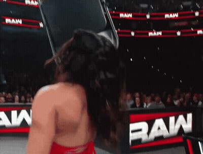 A Woman Is Standing In Front Of A Sign That Says Raw GIF