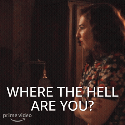 A Woman Is Standing In Front Of A Sign That Says Where The Hell Are You GIF