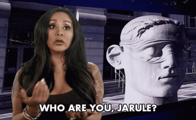 A Woman Is Standing In Front Of A Statue And Asking Who Are You Jarule GIF