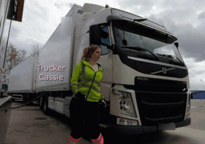 A Woman Is Standing In Front Of A Volvo Truck With The Name Trucker Cassie Written On It GIF