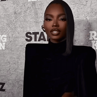 A Woman Is Standing In Front Of A Wall That Says Star GIF