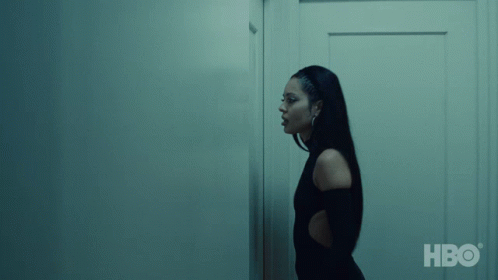 A Woman Is Standing In Front Of A Wall With Hbo Written On The Bottom Right GIF