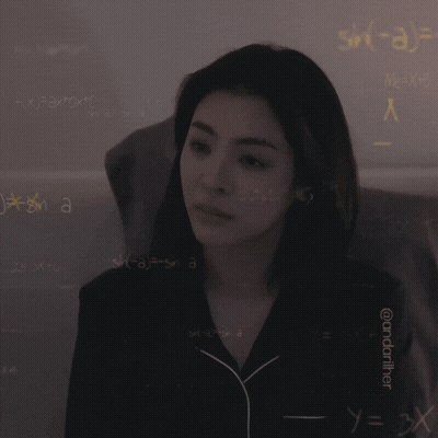 A Woman Is Standing In Front Of A Wall With Mathematical Equations On It GIF