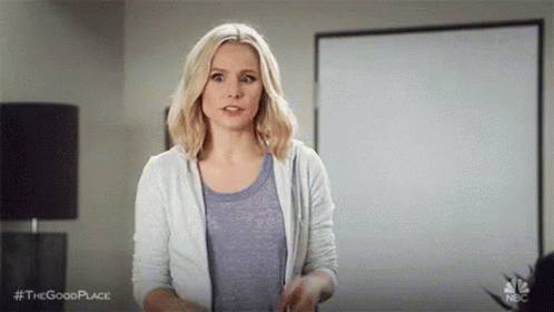 A Woman Is Standing In Front Of A White Board In A Living Room . GIF