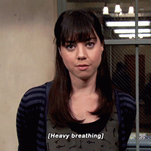 A Woman Is Standing In Front Of A Window And Says " Heavy Breathing " GIF