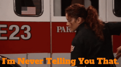 A Woman Is Standing In Front Of An Ambulance With The Number 23 On It GIF