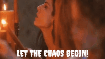 A Woman Is Standing In Front Of Candles With The Words Let The Chaos Begin GIF