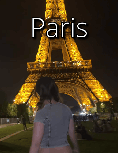 A Woman Is Standing In Front Of The Eiffel Tower At Night With The Word Paris Above Her GIF