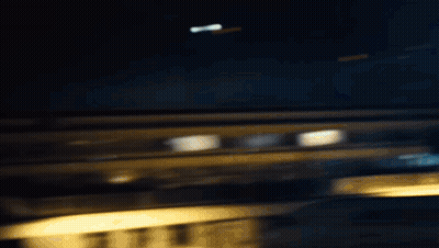 A Woman Is Standing In The Dark Wearing A Ripped Shirt And Black Pants . GIF