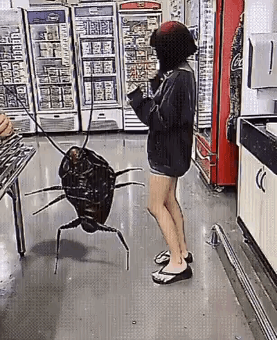 A Woman Is Standing Next To A Giant Cockroach On A Leash In A Store . GIF