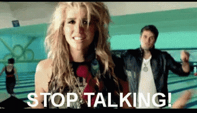 A Woman Is Standing Next To A Man In A Bowling Alley With The Words `` Stop Talking '' Written On The Screen . GIF