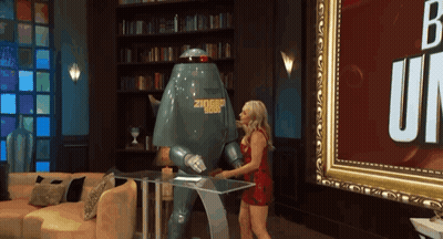 A Woman Is Standing Next To A Robot That Says Ziggy 1988 GIF