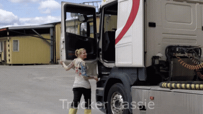 A Woman Is Standing Next To A Truck With The Word Trucker Cassie On The Bottom GIF
