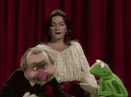 A Woman Is Standing Next To Kermit The Frog And Mr. Frog GIF