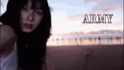 A Woman Is Standing On A Beach With The Word Army Behind Her GIF