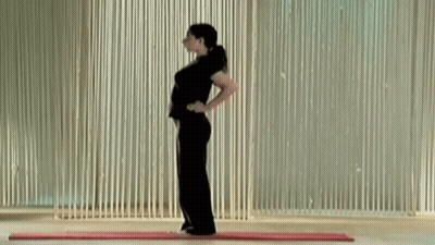 A Woman Is Standing On A Mat With Her Hands On Her Hips . GIF