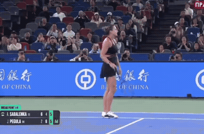 A Woman Is Standing On A Tennis Court In Front Of A Bank Of China Banner GIF
