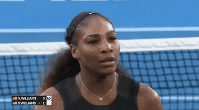 A Woman Is Standing On A Tennis Court With A Scoreboard Behind Her . GIF