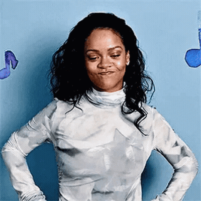 A Woman Is Standing With Her Hands On Her Hips In Front Of A Blue Wall With Music Notes . GIF