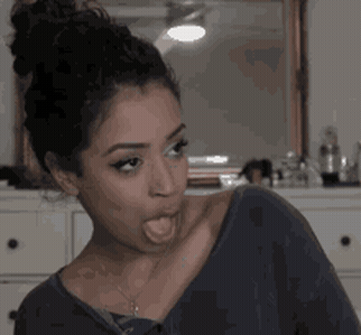 A Woman Is Sticking Her Tongue Out And Making A Funny Face GIF