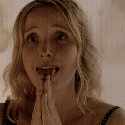 A Woman Is Sticking Her Tongue Out While Praying With Her Hands Together . GIF