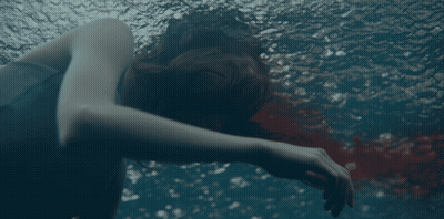 A Woman Is Swimming In A Pool With Her Head Down GIF